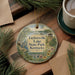 A decorative ornament featuring a scenic image of Taylorville Lake State Park, Kentucky, surrounded by pine branches and a cup of coffee on a wooden surface.