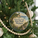 A round ornament hanging on a Christmas tree, featuring a scenic image of Traverse City State Park, Michigan.
