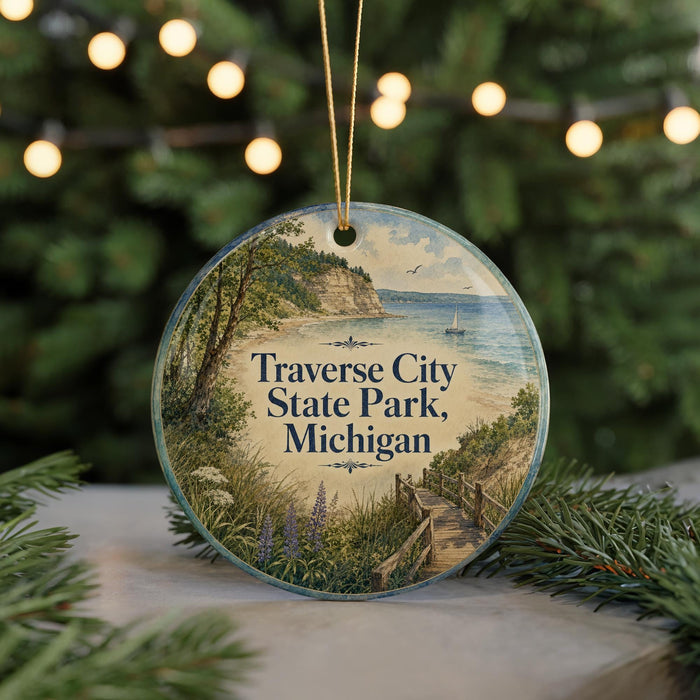 A round ornament with a scenic image of Traverse City State Park, Michigan, featuring a wooden walkway leading to a beach and a cliff overlooking the water.