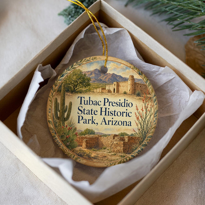 A decorative ornament in a box, featuring a desert landscape with a castle and mountains in the background.