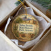 A decorative ornament in a box, featuring a desert landscape with a castle and mountains in the background.