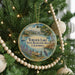 A circular ornament hanging on a Christmas tree, featuring a scenic image of Turlock Lake, California.