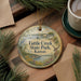 A decorative ornament with the text "Tuttle Creek State Park, Kansas" on it, surrounded by pine branches and a cup of coffee on a wooden surface.