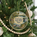A round ornament hanging on a Christmas tree, featuring a scenic image of Twin Lakes State Park, Iowa.