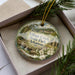 A decorative ornament with a scenic image of Village Creek State Park in Arkansas, featuring a waterfall and pine trees.