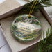A decorative ornament with a scenic image of Wadsworth Falls, a waterfall in Connecticut, surrounded by greenery.