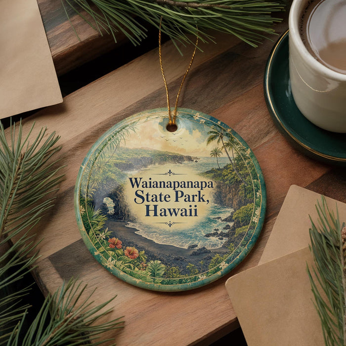A circular ornament with a scenic image of Waianapapa State Park, Hawaii, is displayed on a wooden surface alongside a cup of coffee and some pine branches.