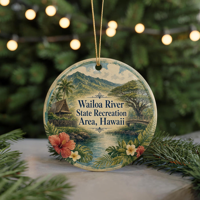 A circular ornament with a tropical landscape design, featuring a river, palm trees, and a house, is displayed in front of a blurred background with Christmas lights.