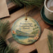 A decorative ornament featuring a scenic view of Waimea State Recreation Pier in Hawaii, surrounded by pine branches and a cup of coffee.