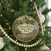 A round ornament hanging on a Christmas tree, featuring a scenic image of Walnut Woods State Park, Iowa.