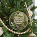 A circular ornament hanging on a Christmas tree, featuring a scenic image of Warren Woods State Park in Michigan.