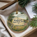 A decorative ornament with a scenic landscape of Wauboards State Park, Iowa, featuring a bird, flowers, and a bridge.