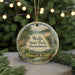 A round ornament with a scenic landscape of Wells State Park, Massachusetts, featuring a bridge, pine trees, and a waterfall.
