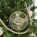 A round ornament hanging on a Christmas tree, featuring a scenic image of Wells State Park, Michigan.