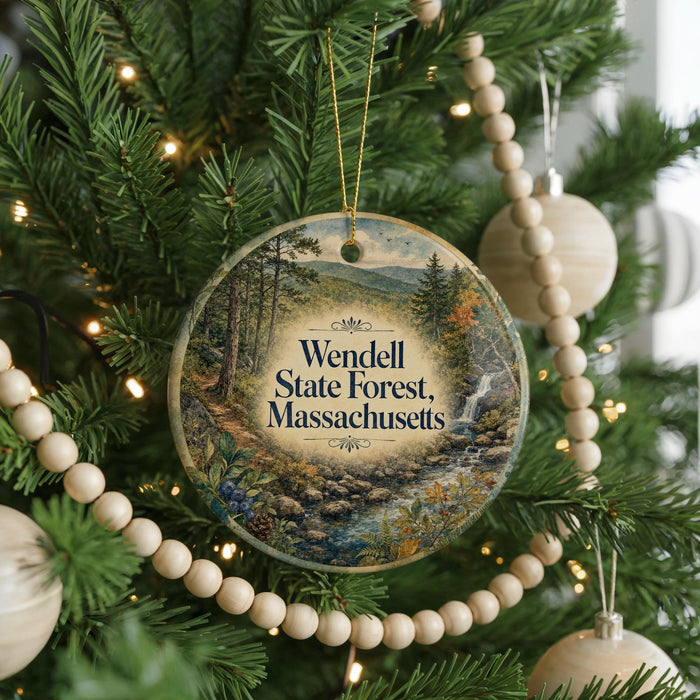 A Christmas tree decorated with ornaments, including a circular ornament with a scenic forest landscape and the text "Wendell State Forest, Massachusetts".