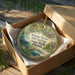 A round ornament in a box, featuring a scenic image of a pond with a bird and palm trees, along with the text "Werner-Boyce Salt Springs State Park, Florida".