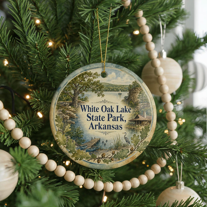 A round ornament hanging on a Christmas tree, featuring a scenic image of White Oak Lake State Park in Arkansas.