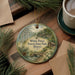 A round ornament with a scenic image of White Pines Forest State Park in Illinois, featuring pine trees, a cabin, and a river.