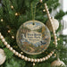 A round ornament hanging on a Christmas tree, featuring a scenic image of Wild River State Park in Minnesota.