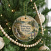 A round ornament hanging on a Christmas tree, featuring a scenic image of Wilderness State Park, Michigan.