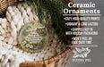 Ceramic ornaments, featuring a ceramic ornament with a house design, are displayed in a basket with pine branches.