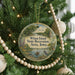 A round ornament on a Christmas tree, featuring a scenic landscape with a river, trees, and a bird, along with the text "Wilson Island State Recreation Area, Iowa".