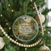 A round ornament hanging on a Christmas tree, featuring a scenic image of springs, state park, and Arkansas.
