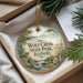 A round ornament with a wolf and a scenic landscape, hanging from a string.