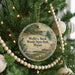A round ornament on a Christmas tree, featuring a scenic image of Wolf's Neck Woods State Park, Maine.