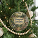 A round ornament hanging on a Christmas tree, featuring a scenic image of Wompatuck State Park in Massachusetts.