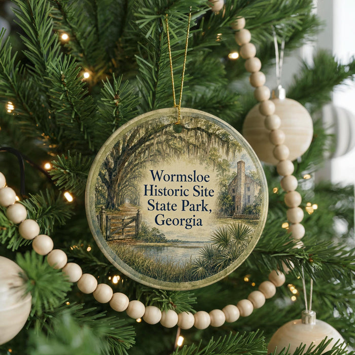A round ornament hanging on a Christmas tree, featuring a scenic image of a historic site in Georgia.