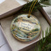 A decorative ornament in a box, featuring a scenic image of the Yampa River State Park in Colorado.