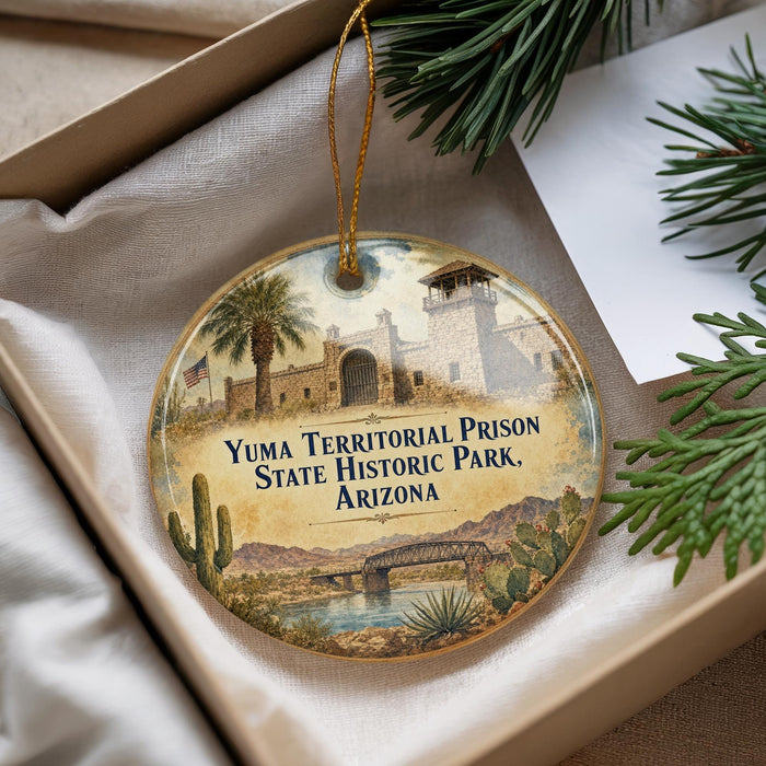 A decorative ornament with a painting of a historical building, specifically Yuma Territorial Prison, surrounded by desert scenery and cacti.