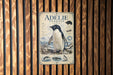 A poster of an Adelie penguin is displayed on a wooden wall.