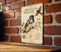 a vintage-style metal sign with illustrations and text, mounted on a brick wall.