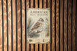 a poster of a sparrow perched on a pine branch, mounted on a wooden wall.
