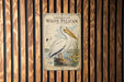 a vintage-style poster of a pelican, which is mounted on a wooden wall.