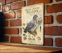 A vintage-style metal sign with illustrations and text about pigeons is mounted on a brick wall.