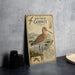 A vintage metal sign featuring an illustration of a bar-tailed godwit, a wading bird, standing in a natural setting.