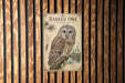 a vintage-style poster of a barred owl, which is mounted on a wooden wall.