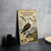a vintage-style illustration of a black-footed albatross, a large seabird, standing on a rock near the ocean. The illustration includes detailed illustrations of the bird's physical features and its natural habitat.