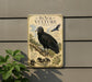 a vintage-style metal plaque with an illustration of a black vulture, mounted on a wall.