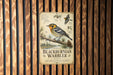 a vintage-style metal sign with illustrations and text, mounted on a wooden wall.