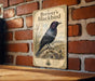 A vintage-style sign for "Brewer's Blackbird" is displayed on a brick wall, featuring an illustration of the bird perched on a branch with wildflowers.