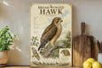a large poster of a broad-winged hawk, with a detailed illustration of the bird and its natural habitat. The poster is displayed on a shelf next to a wooden cutting board and a potted plant.