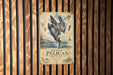a vintage-style poster of a pelican diving into the water, mounted on a wooden wall.