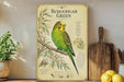 a vintage-style poster or painting of a Budgerigar Green parrot, which is a type of parrot, displayed on a wall. The poster includes detailed illustrations and text about the Budgerigar Green parrot, as well as some additional text and images related to the bird.