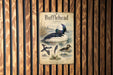 A vintage-style metal sign with illustrations and text, mounted on a wooden wall.