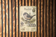 a vintage-style metal sign with illustrations and text about a small bird called Bushit.