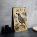 a vintage-style metal plate with illustrations and text about California quails, placed on a table next to some black camera lenses.